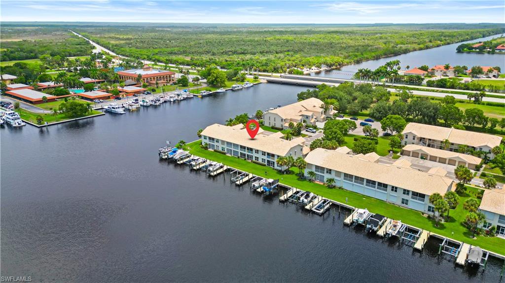 Waterfront residential community featuring multiple buildings with tile roofs and screened lanais