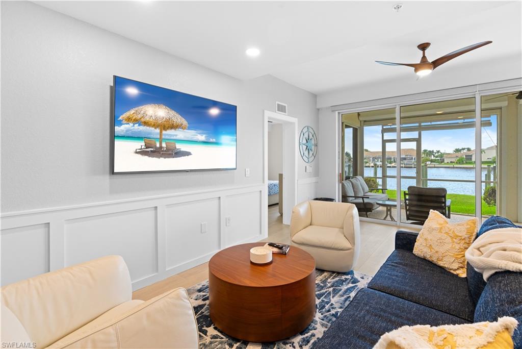 Living area featuring wood-finish flooring, a contemporary ceiling fan, and recessed lighting
