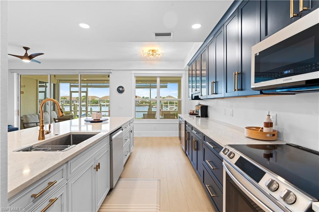 Gourmet kitchen featuring a large central island with an undermount sink and a gooseneck faucet
