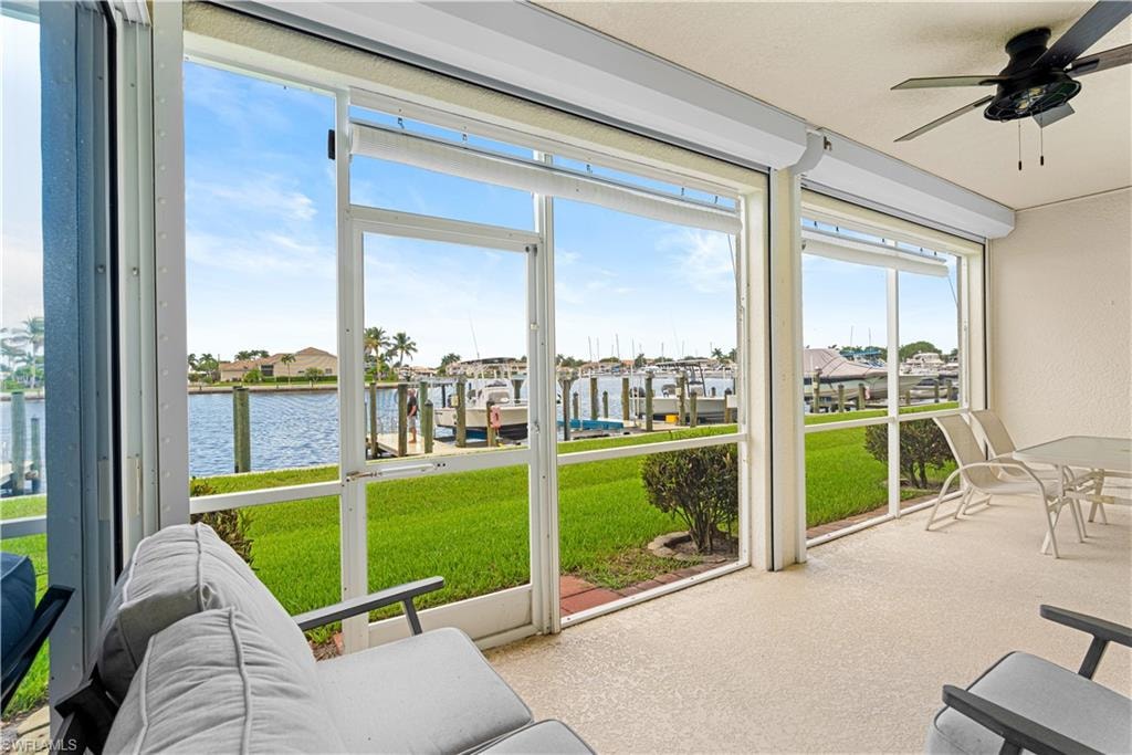 Screened patio with textured flooring, featuring a ceiling fan and retractable sun shades