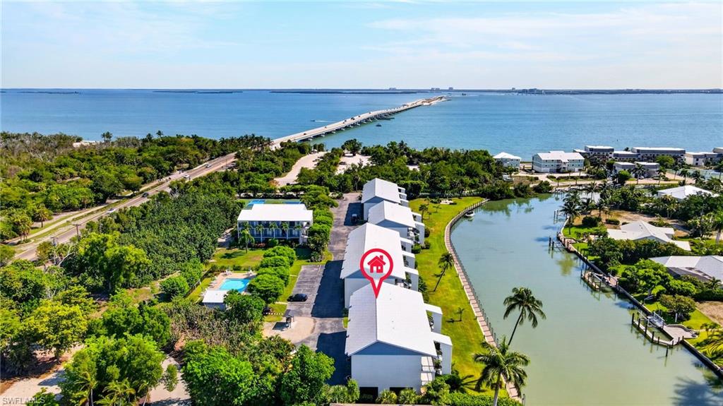 Coastal property featuring direct canal access, a community swimming pool, and proximity to a major bridge