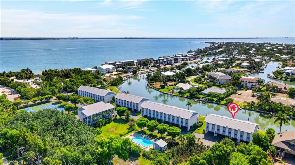 Waterfront community featuring canal access, multiple residential structures, a tennis court, and an outdoor swimming pool