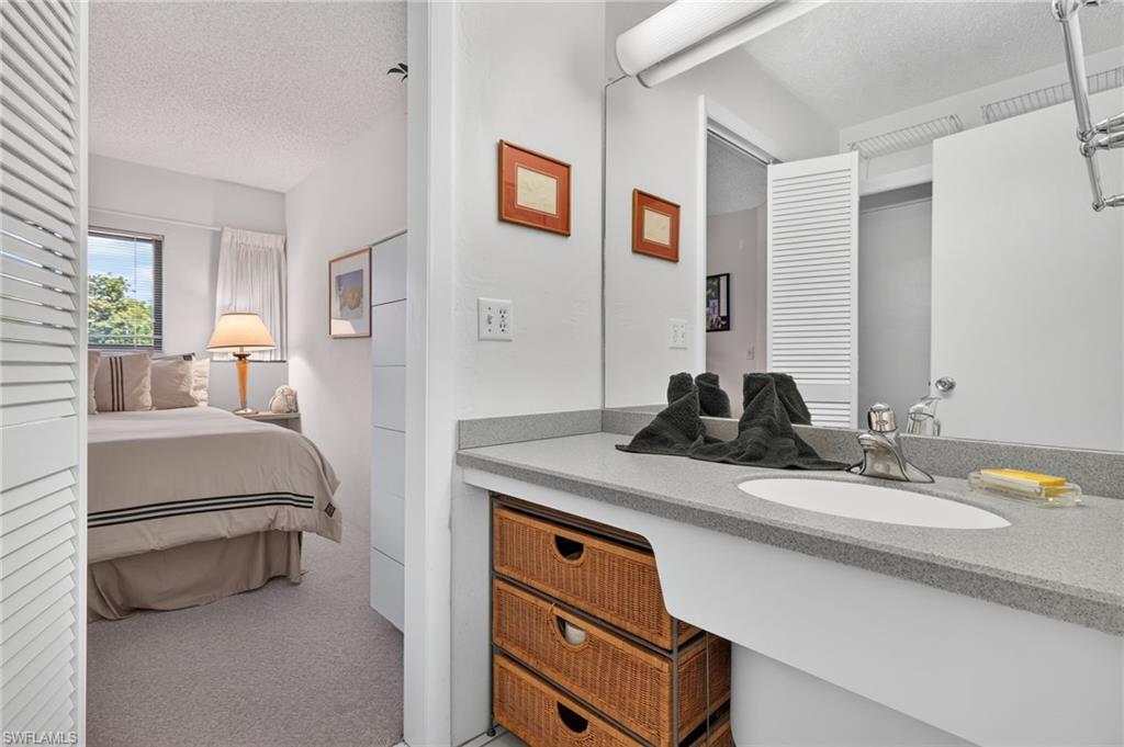 Bathroom vanity featuring a solid surface countertop with integrated sink and chrome faucet