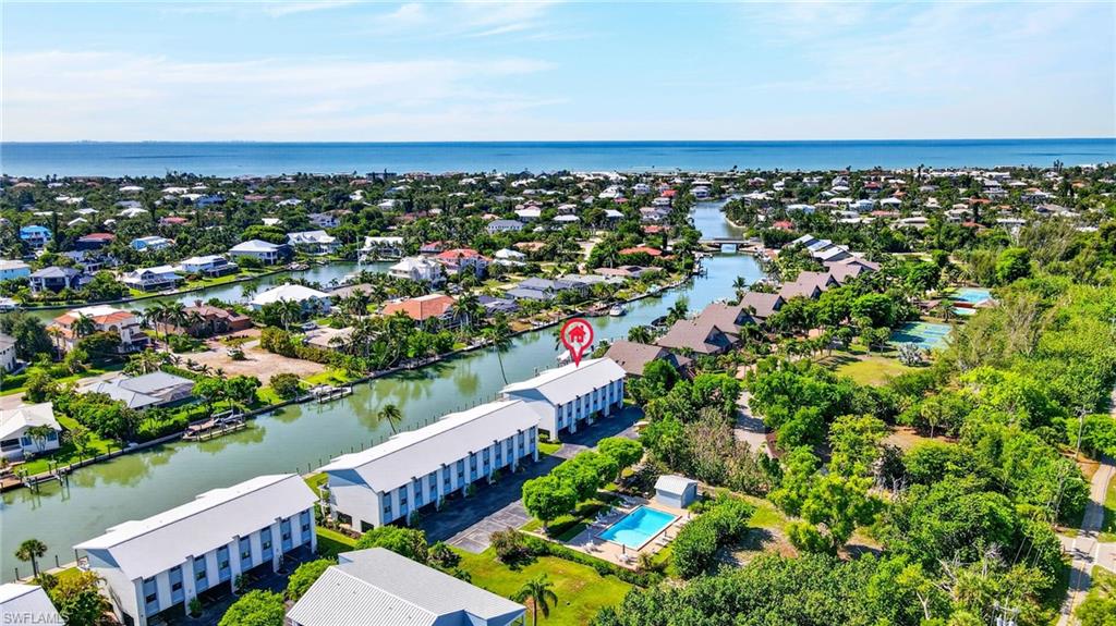 Aerial perspective showcasing a residential community with canal access, multiple buildings, and a clear view of the open water