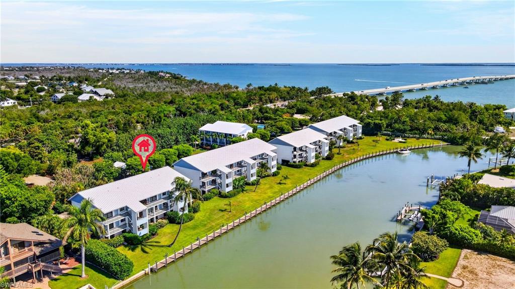 Waterfront multi-story buildings featuring private balconies and lush surrounding foliage