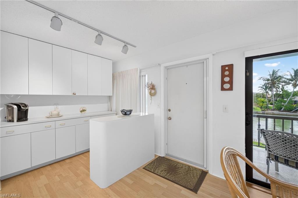 Kitchen featuring white cabinetry, track lighting, and wood-finish flooring