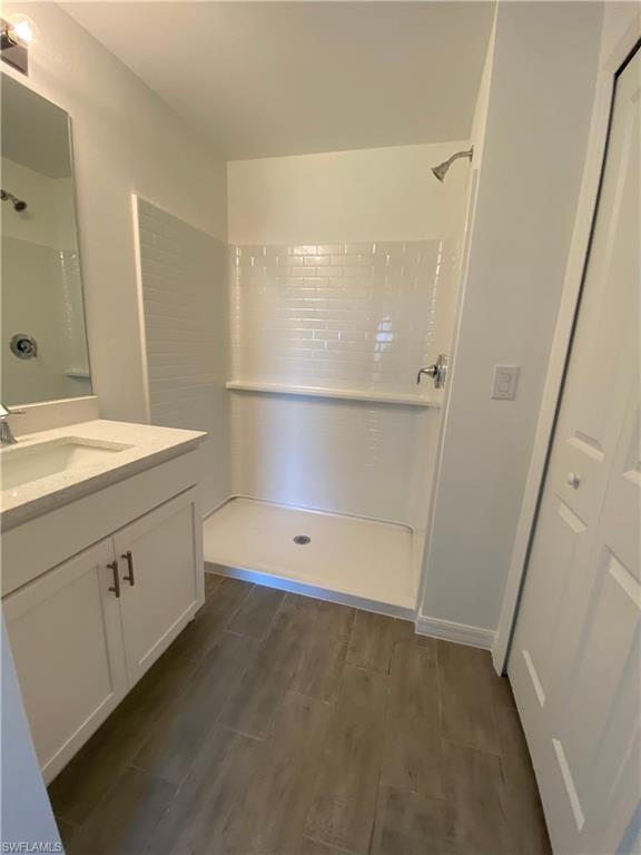 Bathroom featuring a shower, hardwood / wood-style floors, and vanity