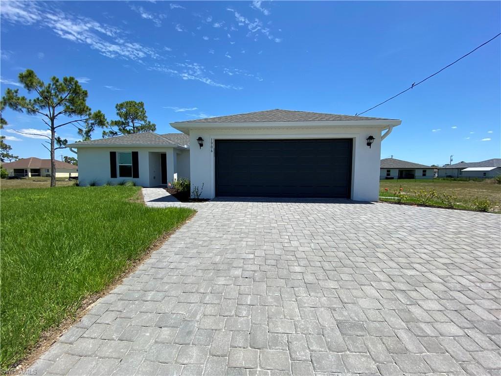 View of front of property featuring a garage and a front lawn