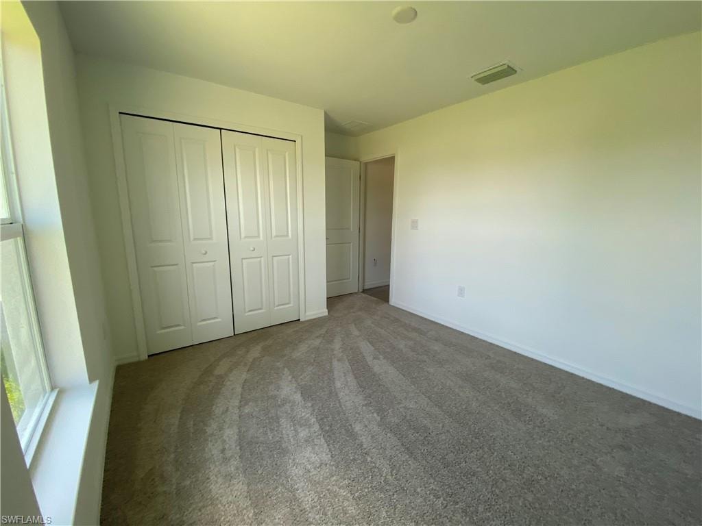 Unfurnished bedroom with carpet flooring and a closet