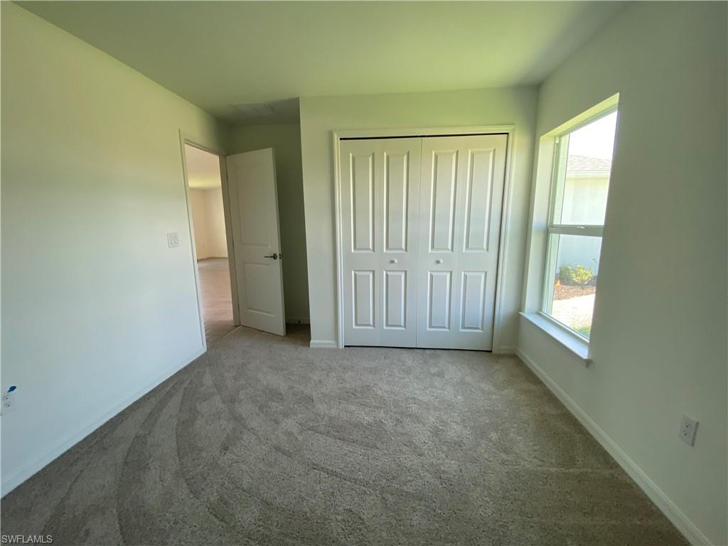 Unfurnished bedroom with a closet and carpet floors