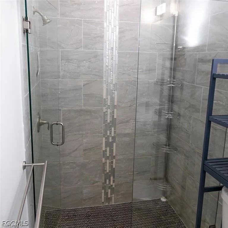 Walk-in shower with clear glass enclosure and brushed nickel fixtures