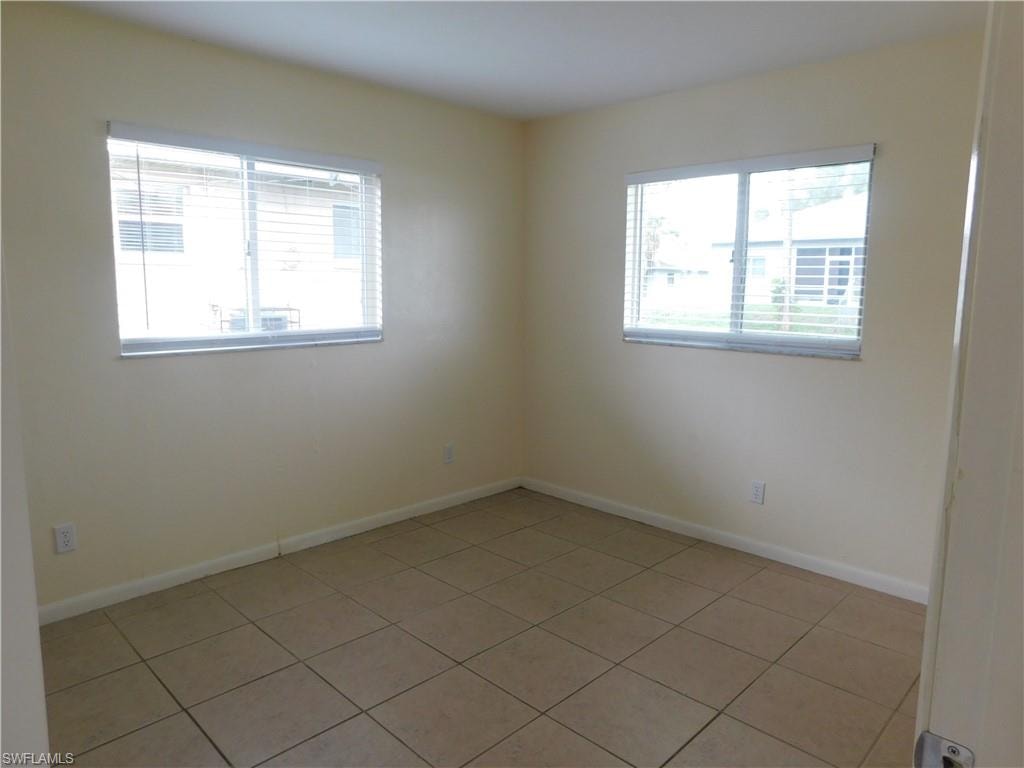 Tiled Guest bedroom featuring two large windows giving great natural light