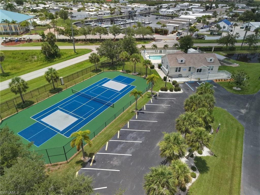 Fenced tennis court and pickleball courts with adjacent parking area