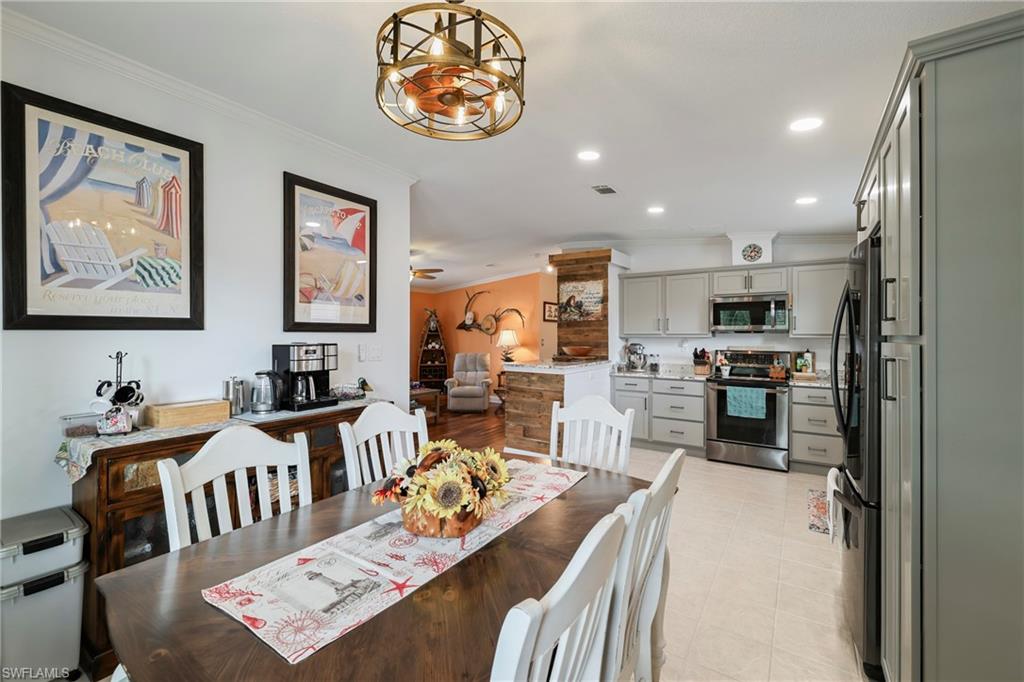 Open-concept dining area featuring a wood-finish table and a chandelier with integrated fan
