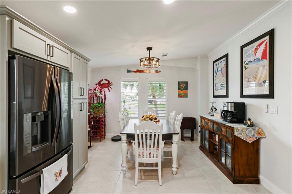 Dining area featuring tile flooring, white walls, and a decorative chandelier
