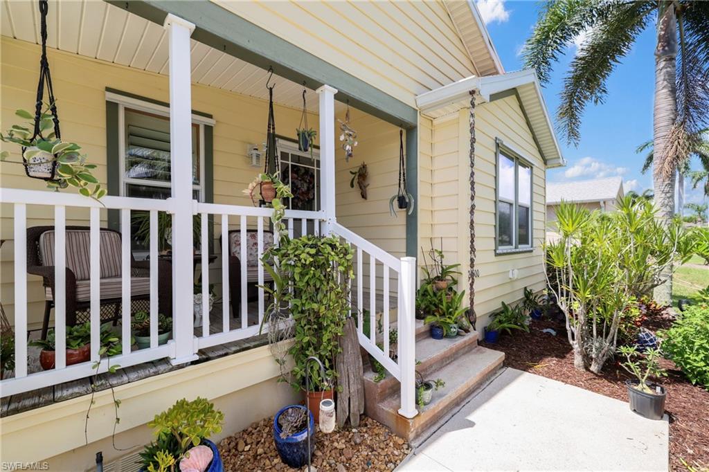 Inviting front porch featuring white railings and a subtle green trim