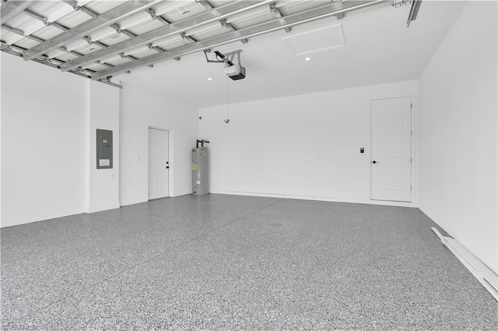 Spacious garage featuring a durable epoxy-coated floor, painted white walls, and an automatic garage door opener system