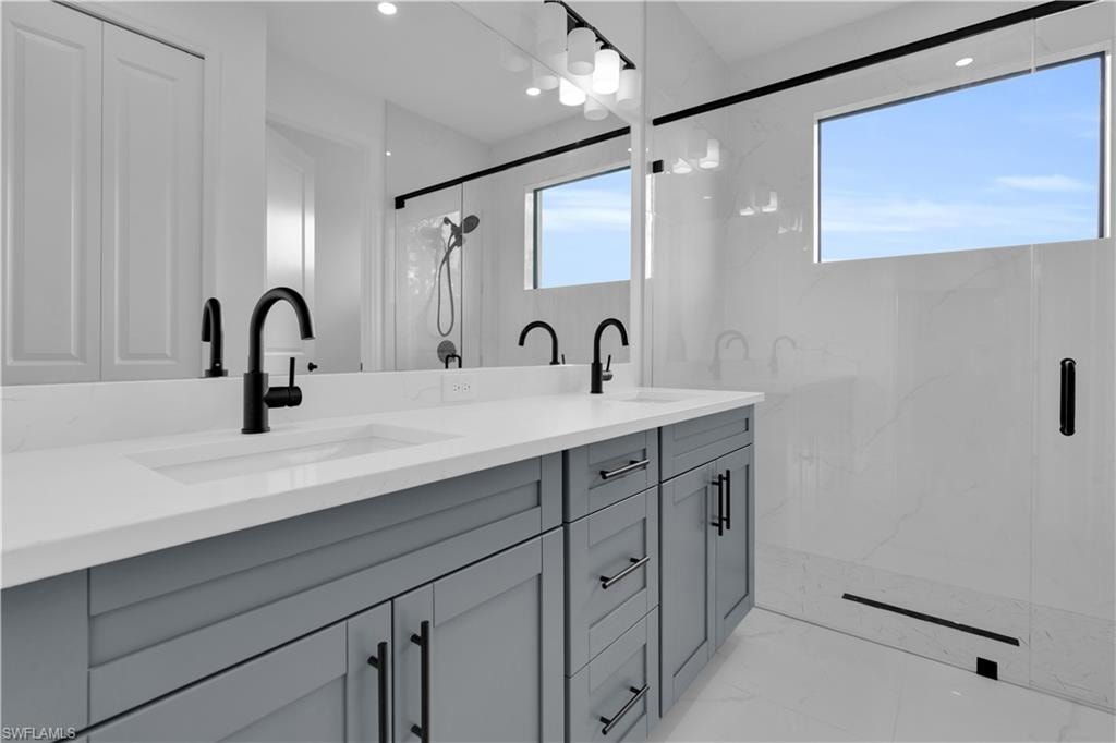Bathroom featuring a double vanity with gray cabinetry and white countertops