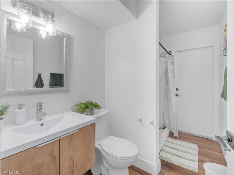 Bathroom featuring a floating wood-finish vanity with an integrated white sink, chrome faucet, and a large framed mirror