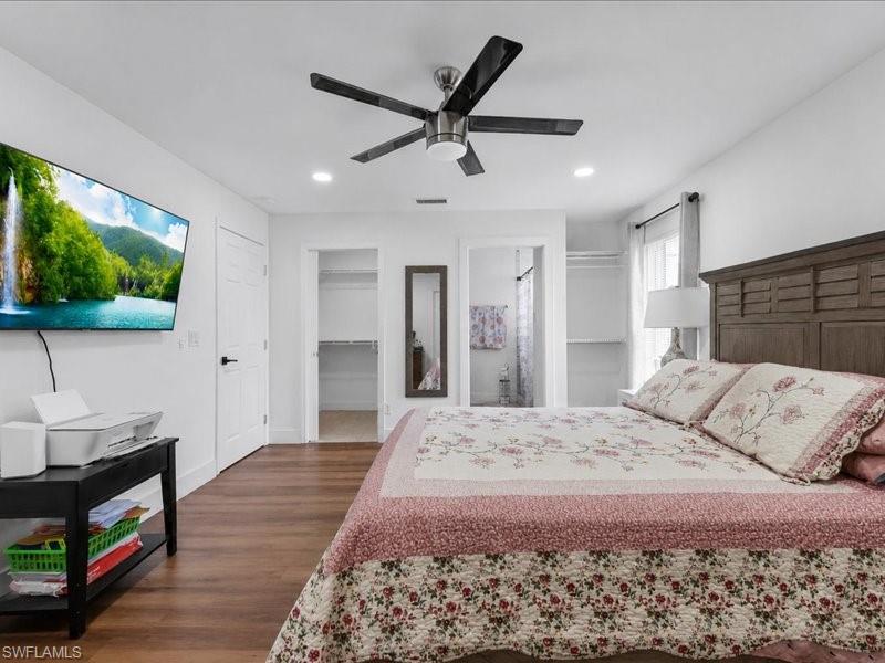 Spacious interior featuring wood-finish flooring, a contemporary ceiling fan, recessed lighting, and white walls
