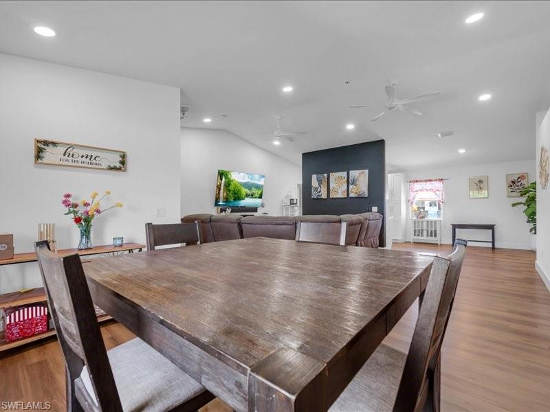 Open-concept interior featuring wood-finish flooring, recessed lighting, and vaulted ceilings