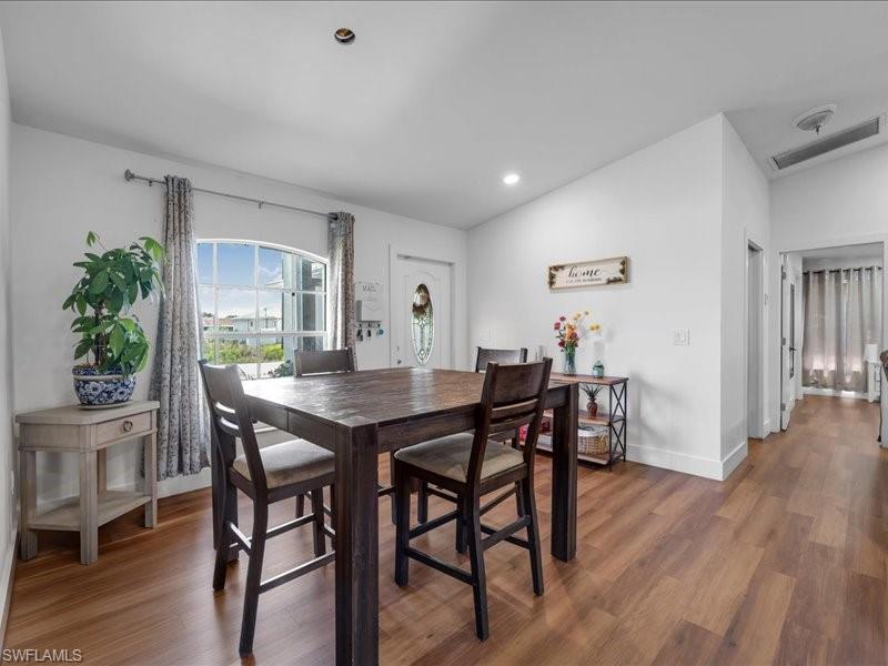 Dining area featuring wood-finish flooring, white walls, and recessed lighting