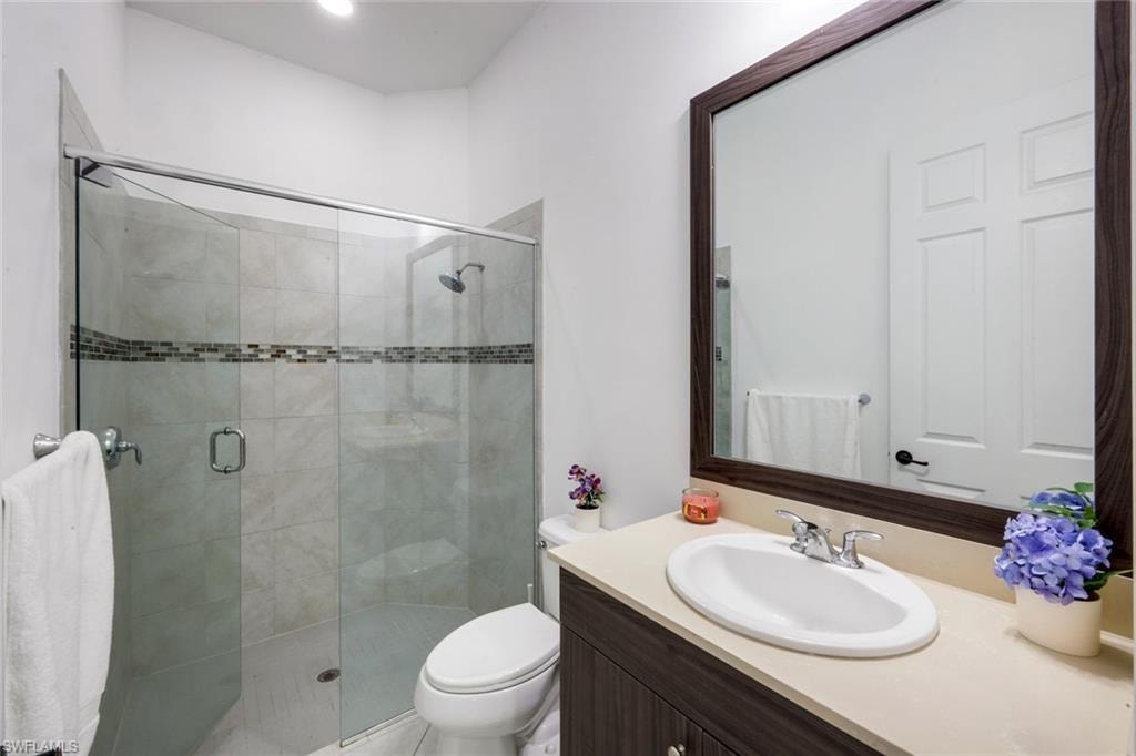 Bathroom featuring a glass-enclosed shower with tile surround and decorative accent band