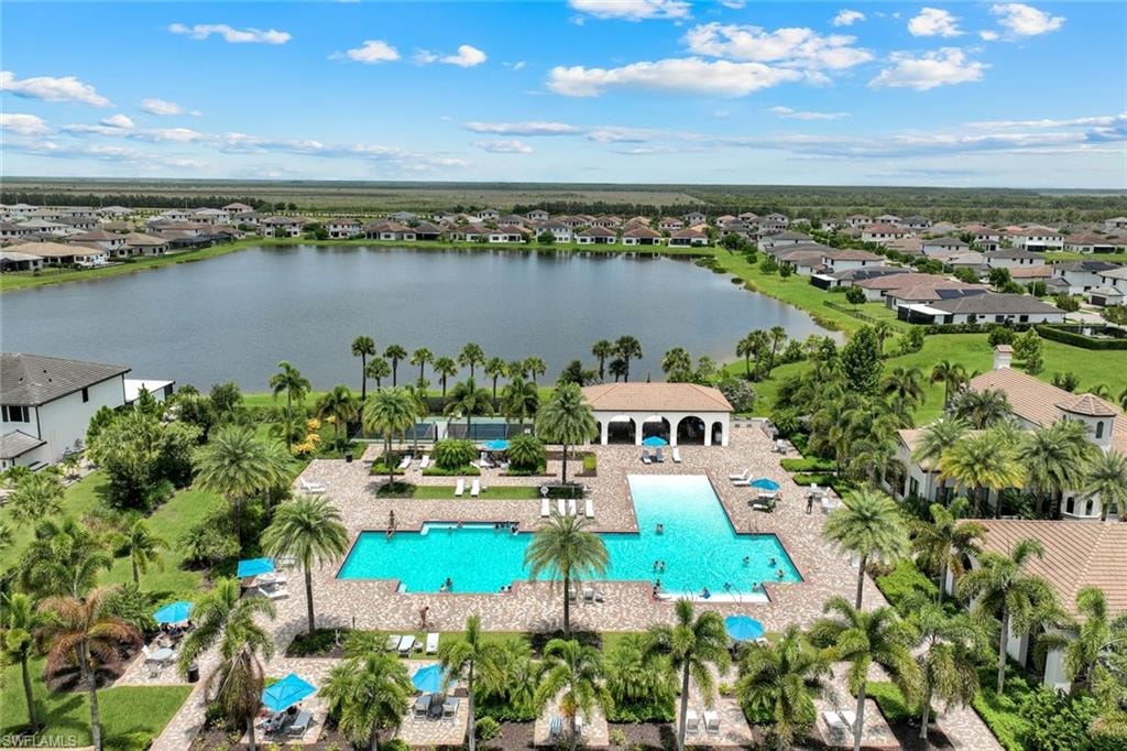 Expansive community amenities featuring a large swimming pool with a sun shelf, a covered patio area, and extensive paver decking