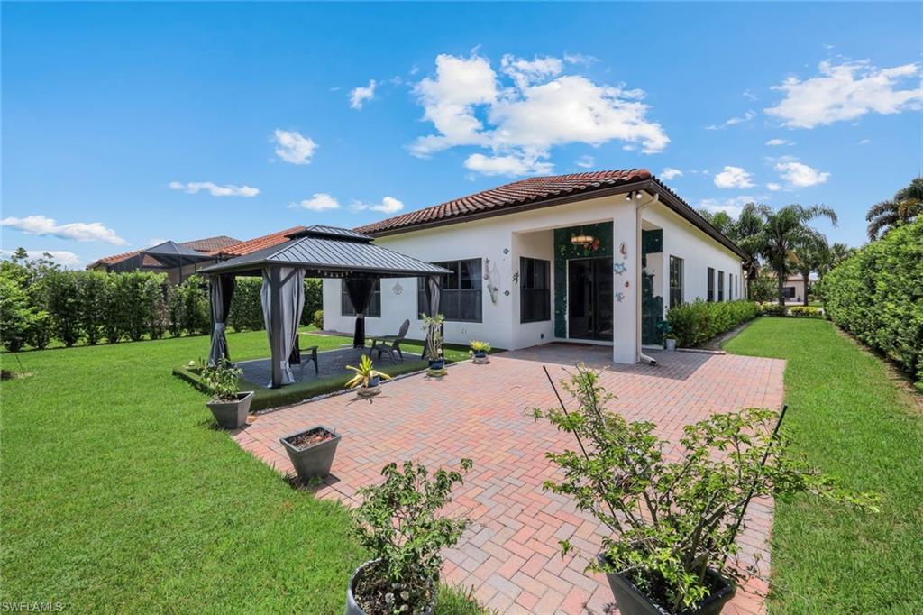 Rear exterior with a red barrel tile roof and a spacious paver patio