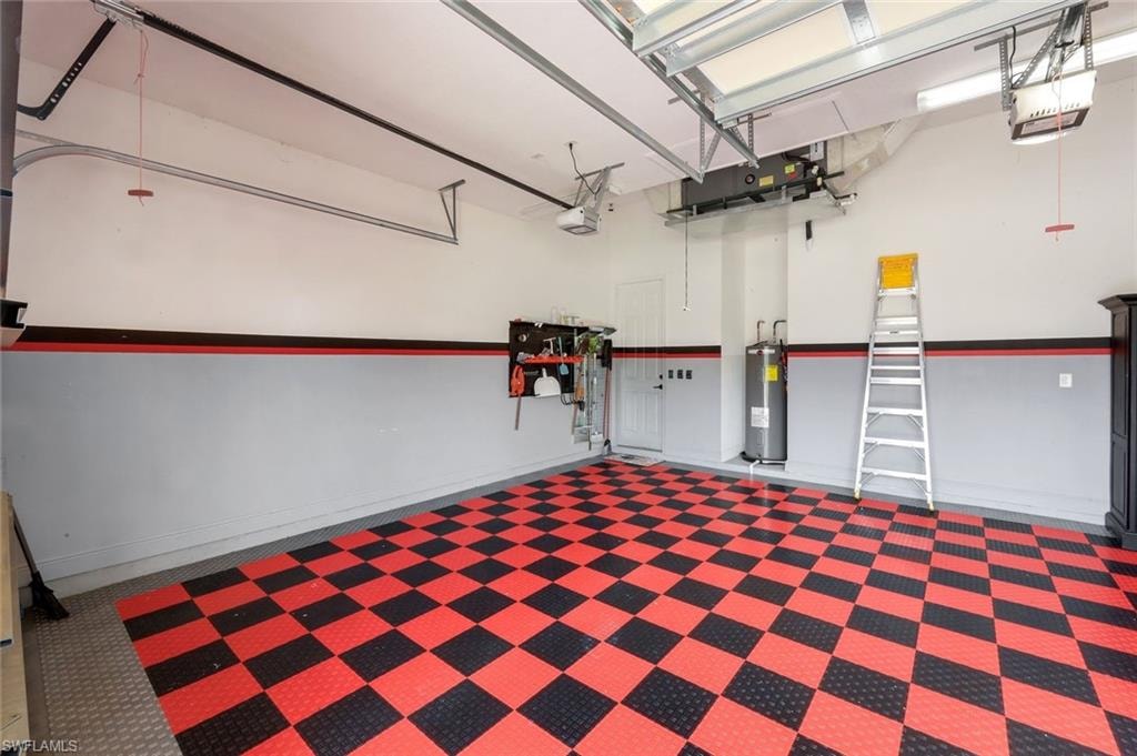 Spacious garage featuring a checkerboard-patterned floor, dual garage door openers, and track lighting