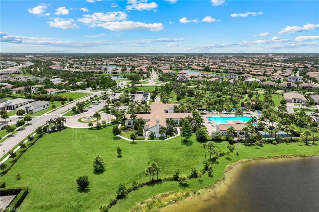 Aerial perspective showcasing a residential community with abundant green spaces and a prominent clubhouse