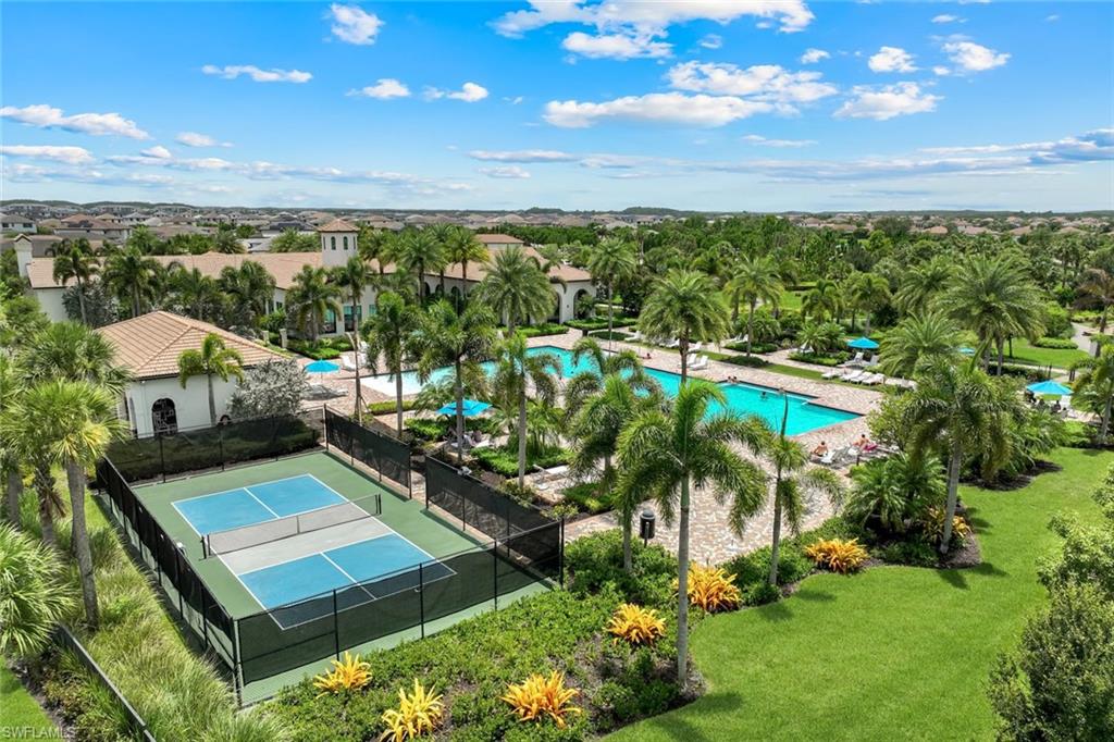 Community amenities featuring a pickleball court, multiple swimming pools, and extensive lush landscaping with palm trees
