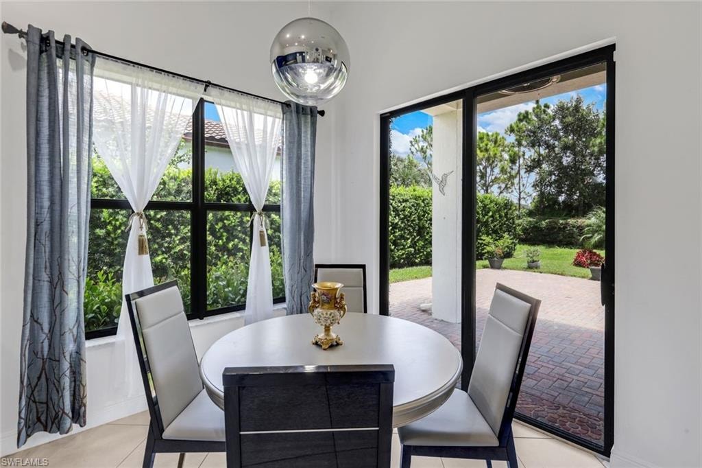 Dining area featuring a contemporary round table, upholstered chairs, and a reflective spherical pendant light
