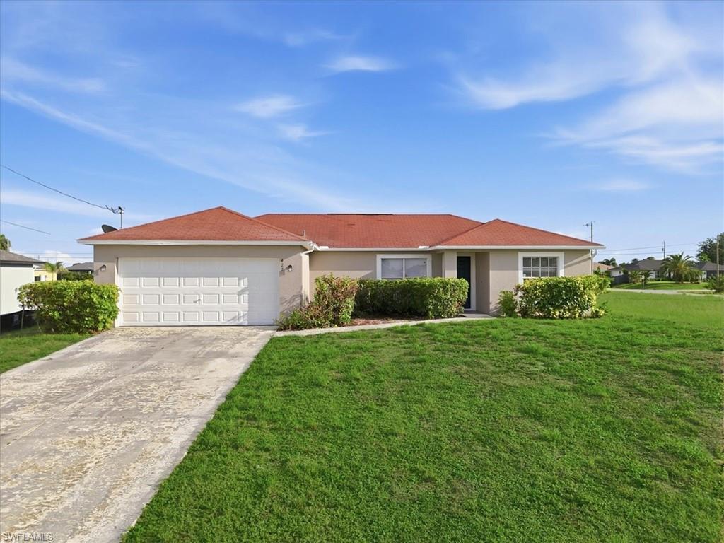 Single-story residence featuring a red tile roof and light-colored stucco exterior