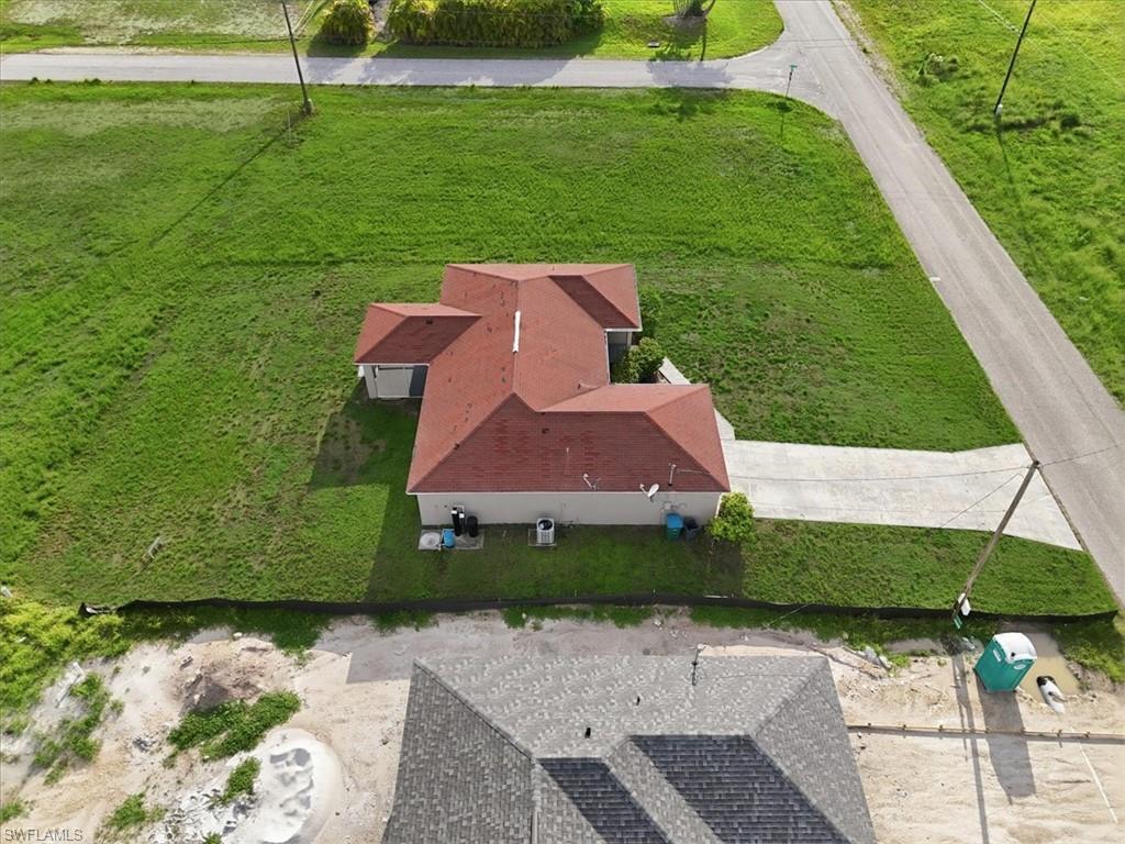 Single-story residence featuring a red shingle roof and light-colored exterior walls