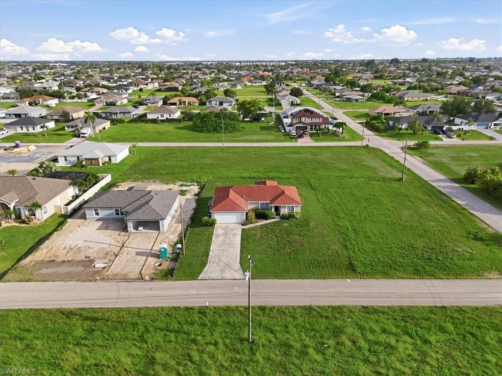 Expansive parcel featuring a single-story residence with a terracotta tile roof, surrounded by green space