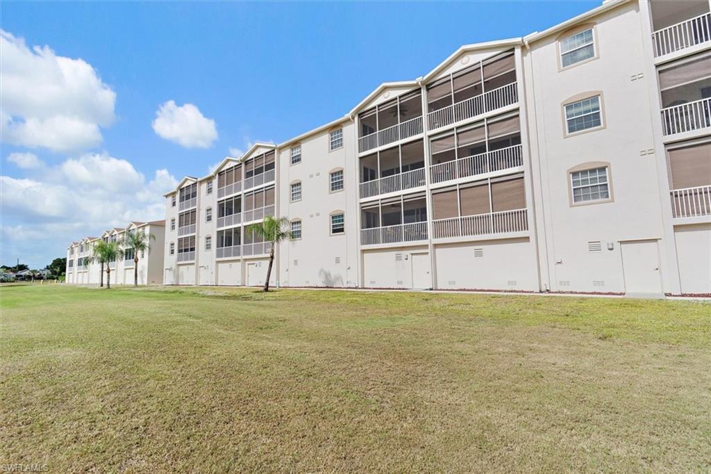 Multi-story condominium building featuring screened lanais with roll-down sunshades, white exterior stucco, and white railings