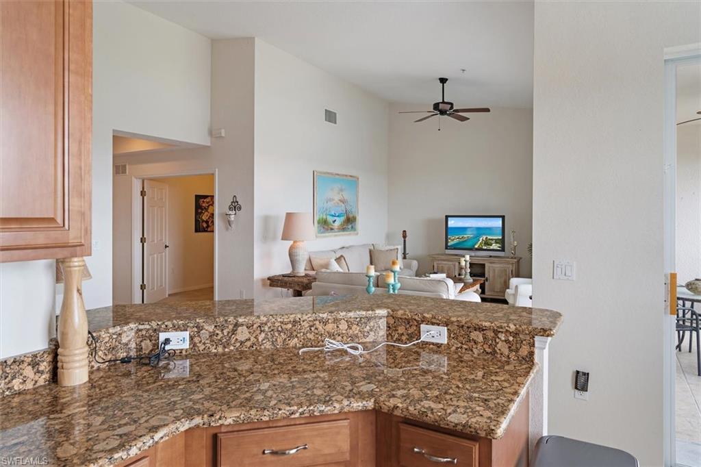 Granite countertop bar with wood cabinetry and electrical outlets