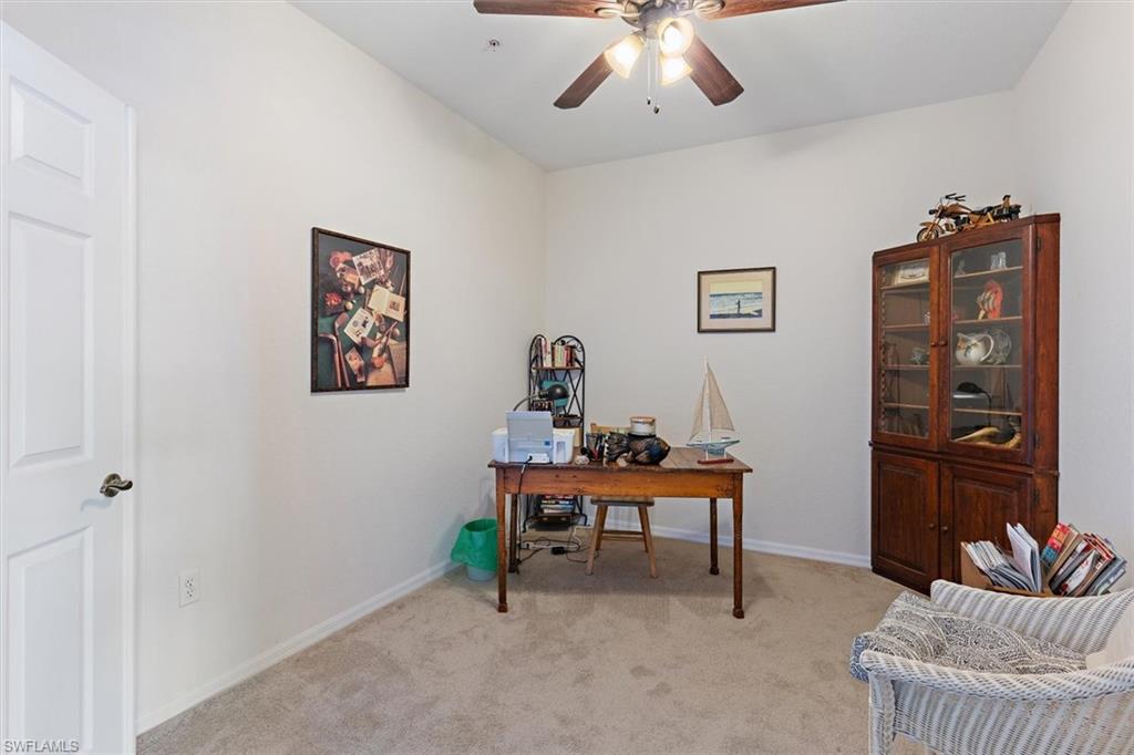 Room featuring a ceiling fan, light-toned carpeting, and a white paneled door