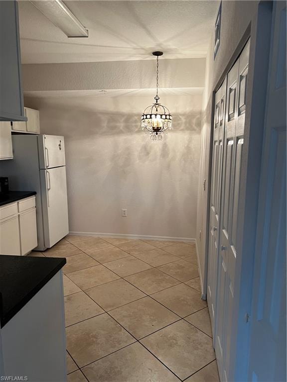 Unfurnished dining area with light tile patterned floors and a chandelier