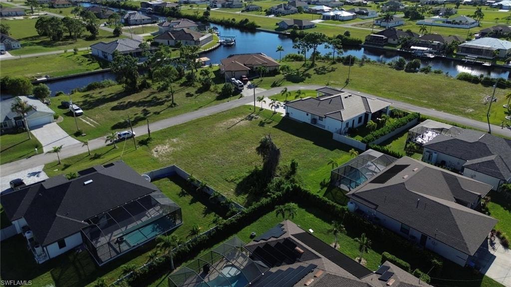 Expansive undeveloped lot with surrounding residential properties, surrounded by a canal system, and lush green landscaping