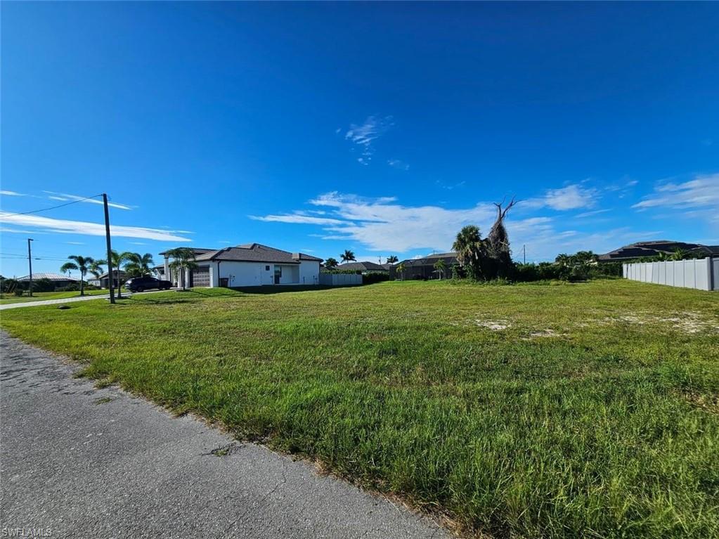 Expansive undeveloped lot featuring a grassed surface and a partial fence line