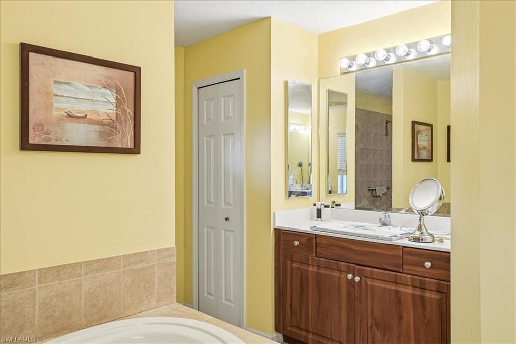 Bathroom featuring a rich wood-finish vanity with a white countertop and integrated sink