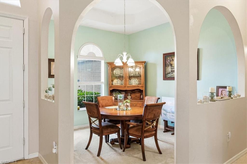 Virtually Staged Open-concept kitchen and dining area featuring a breakfast bar with a double basin sink, dark wood-finish cabinetry, and stainless steel dishwasher