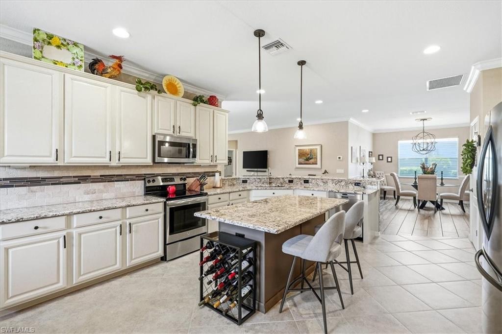Kitchen featuring white cabinetry, stainless steel appliances, a tile backsplash, and light-toned countertops