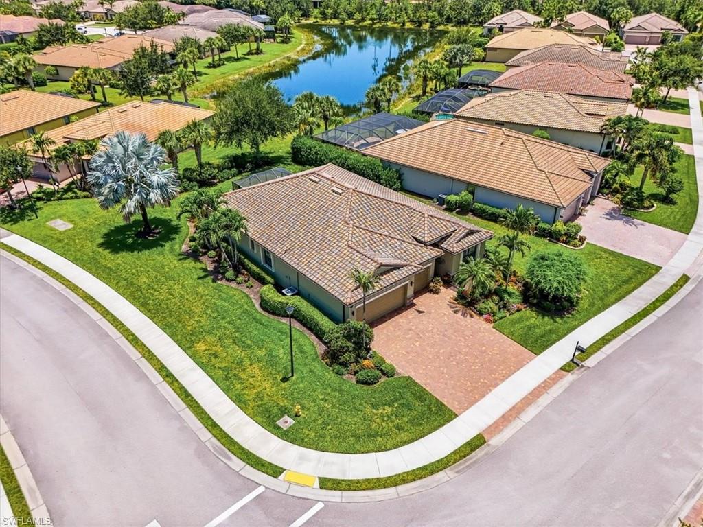 Single-story residence featuring a tile roof, paver driveway, and manicured landscaping