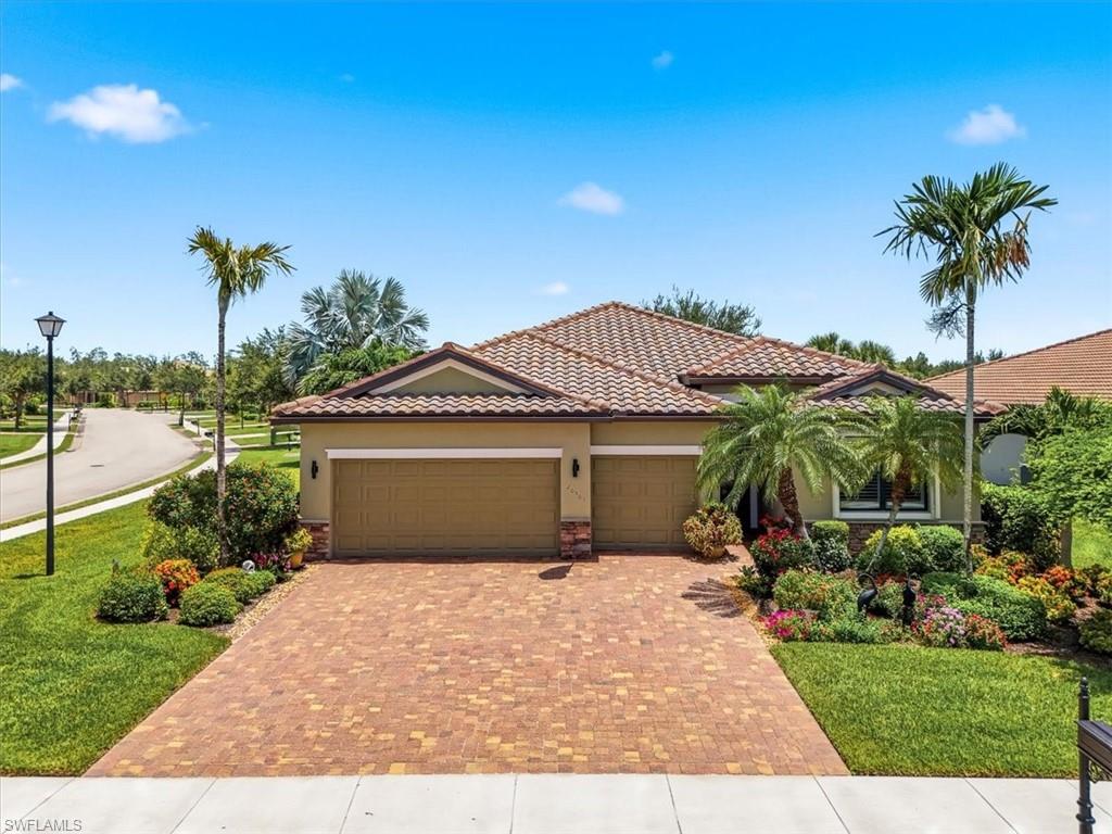 Mediterranean-style residence featuring a tile roof and a paver driveway