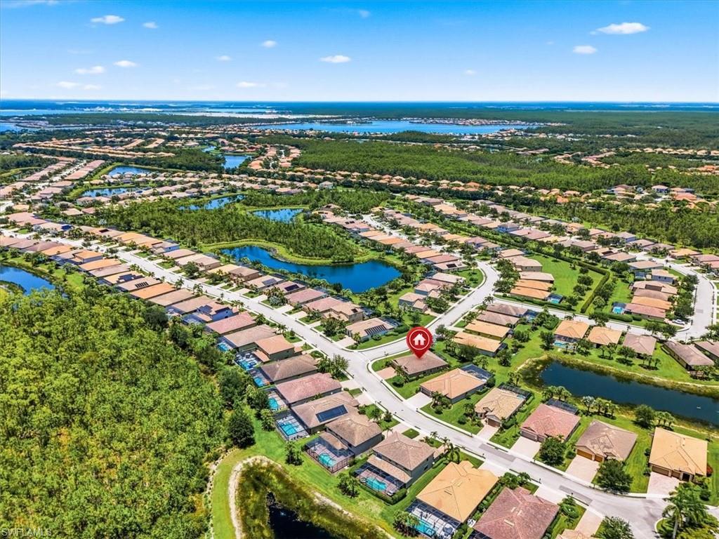Aerial perspective showcasing a residential community with individual properties, winding streets, and multiple water features