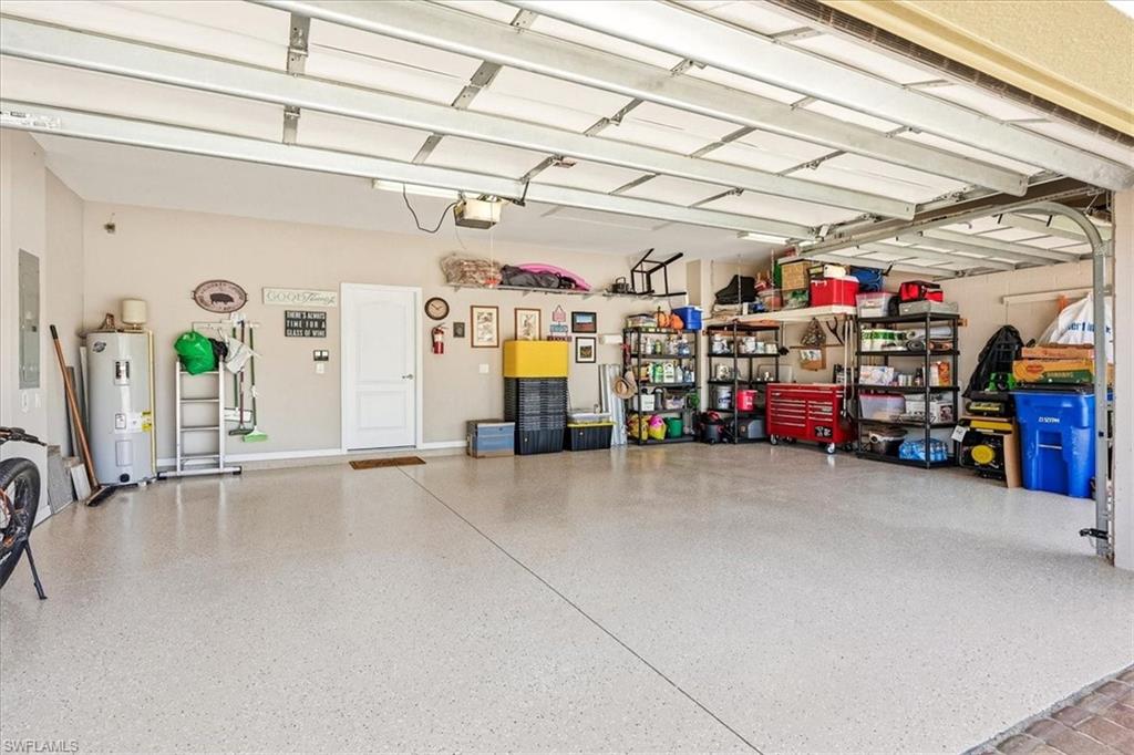 Spacious garage featuring a light-toned epoxy floor, multiple overhead garage doors, and ample wall space