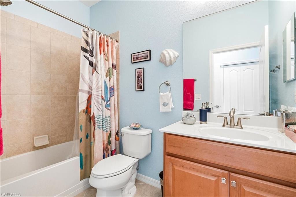 Bathroom featuring a single vanity with wood-finish cabinetry, a white countertop, and a brushed nickel faucet